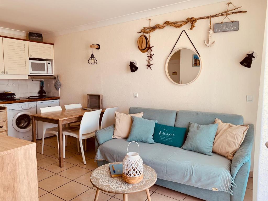 un soggiorno con un divano blu e un tavolo di Appartement rez-de-chaussée entre dunes et ocean a Lacanau-Océan