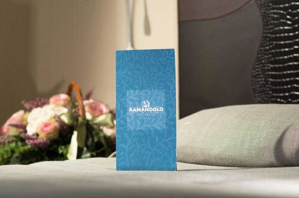 un cartello blu seduto accanto a un mazzo di fiori di Hotel Residence Ristorante Ramandolo a Udine