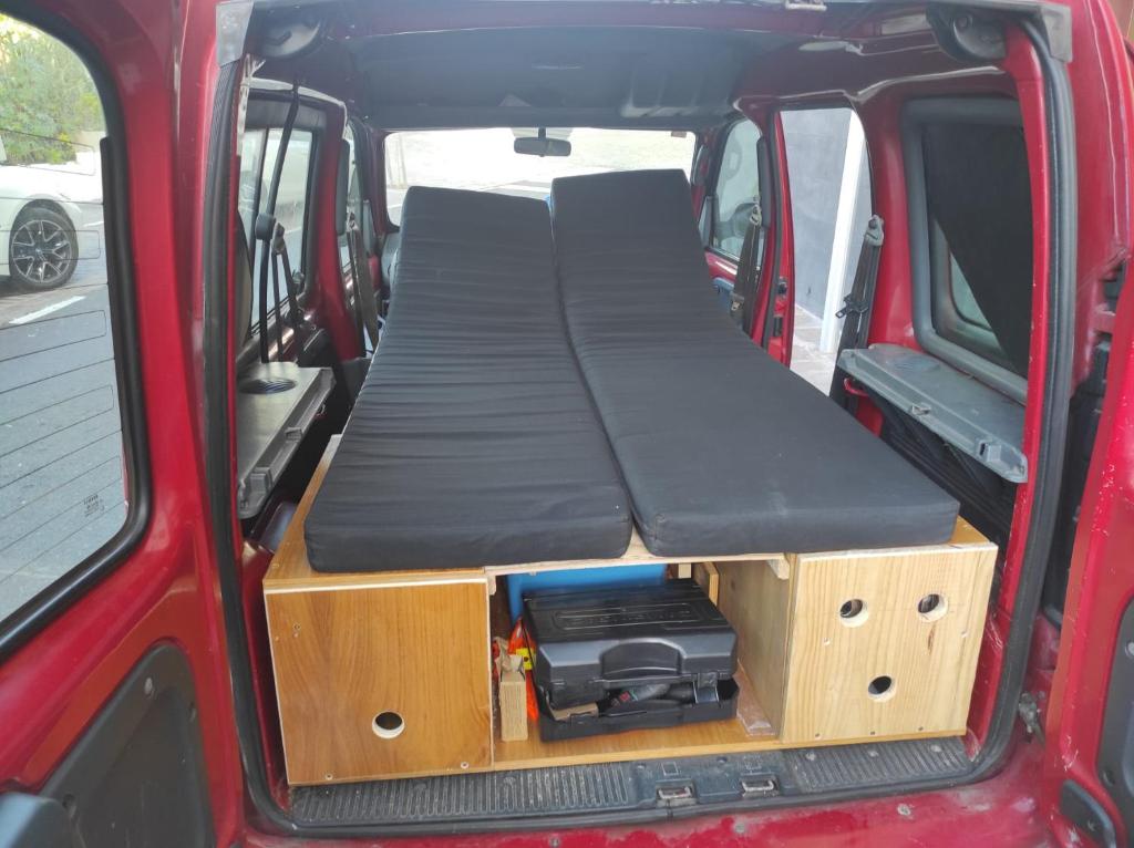 a bed in the back of a red van at Camper K Not for driving Playa las Vistas in Adeje