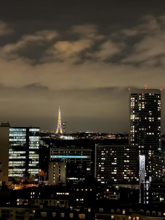 une ligne d'horizon nocturne avec la tour eiffel dans l'établissement Apartement view of all of Paris, à Puteaux