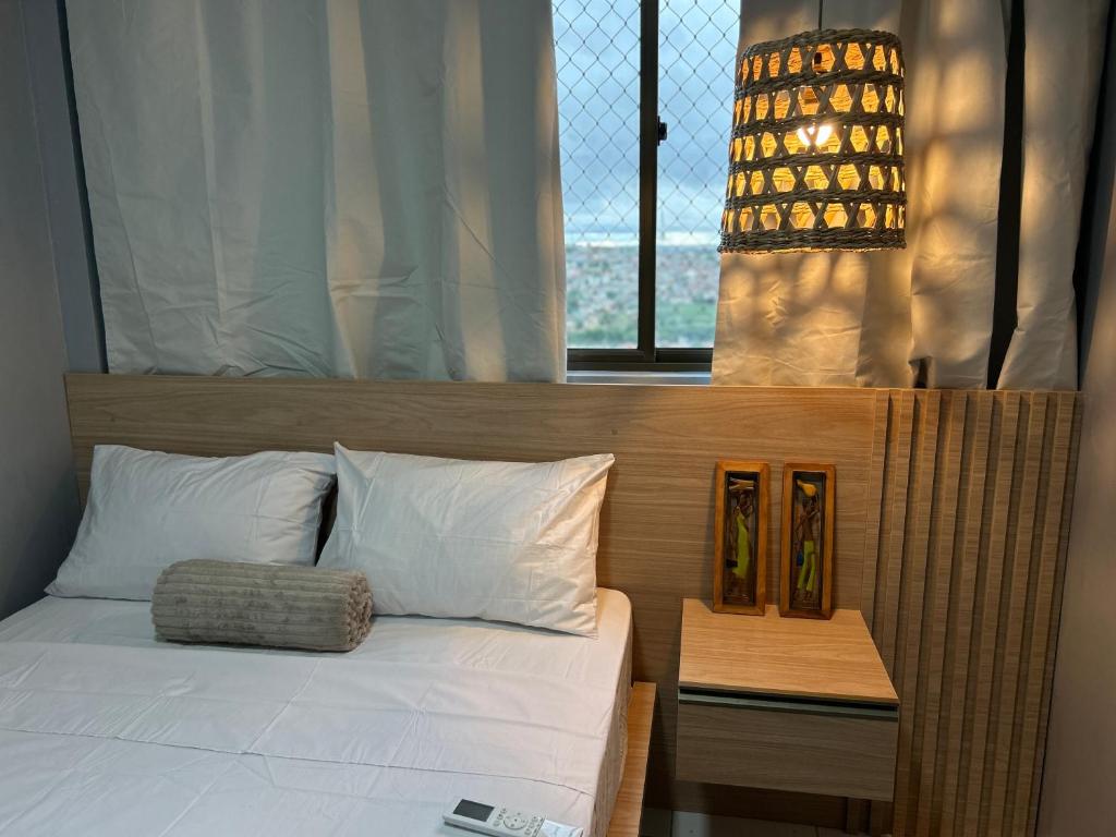 a bedroom with a bed and a window and a table at Perfeito Ap Caruaru in Caruaru