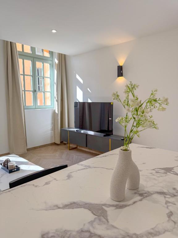 un vase blanc avec une plante assise sur une table dans l'établissement T2 luxe 100 m port, Clim, Wi-Fi, à Toulon