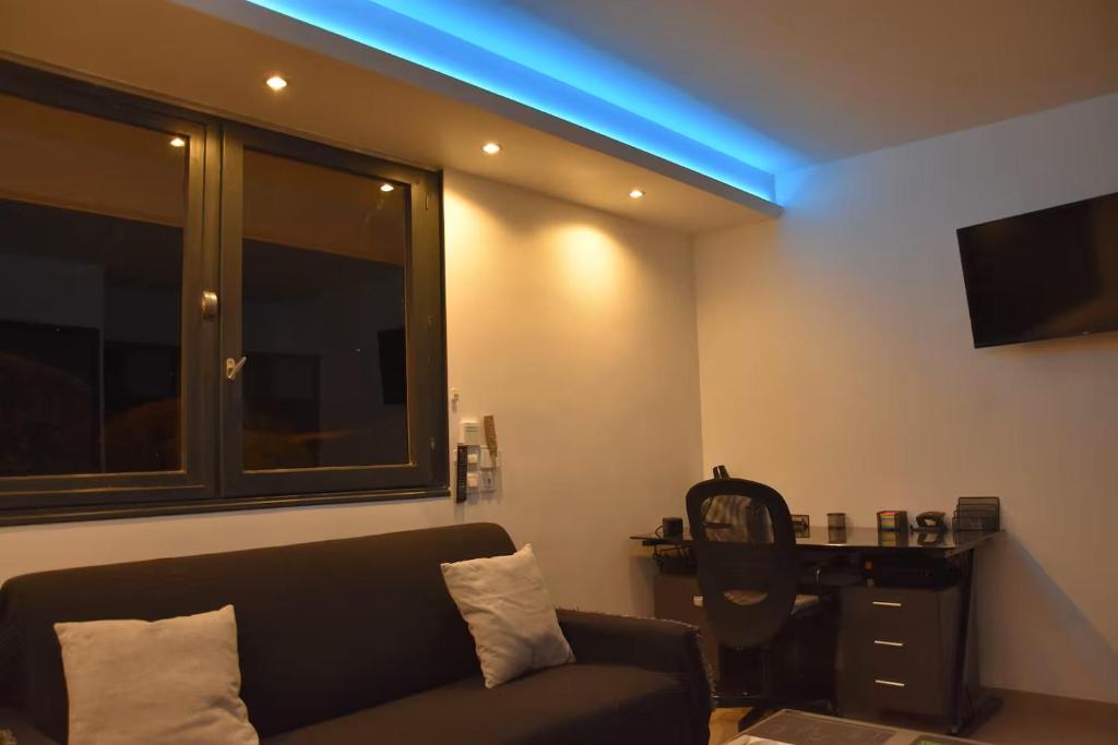 un salon avec un canapé et une lumière bleue dans l'établissement Studio de Julien, à Châtenay-Malabry