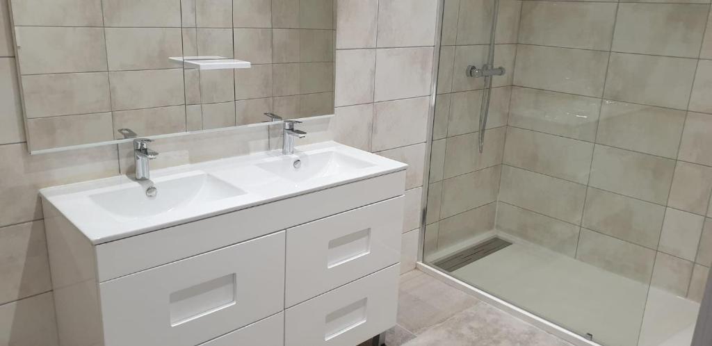 une salle de bain avec un lavabo blanc et une douche dans l'établissement Chez lili, à Ghisonaccia