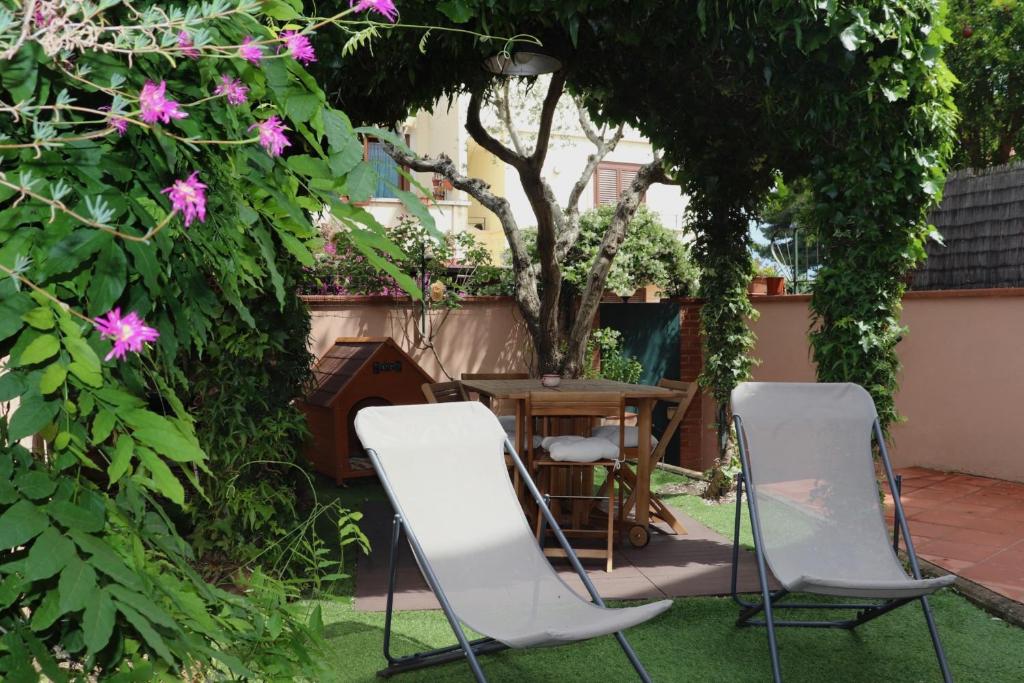 two chairs and a table in a garden with flowers at Il Glicine in Livorno
