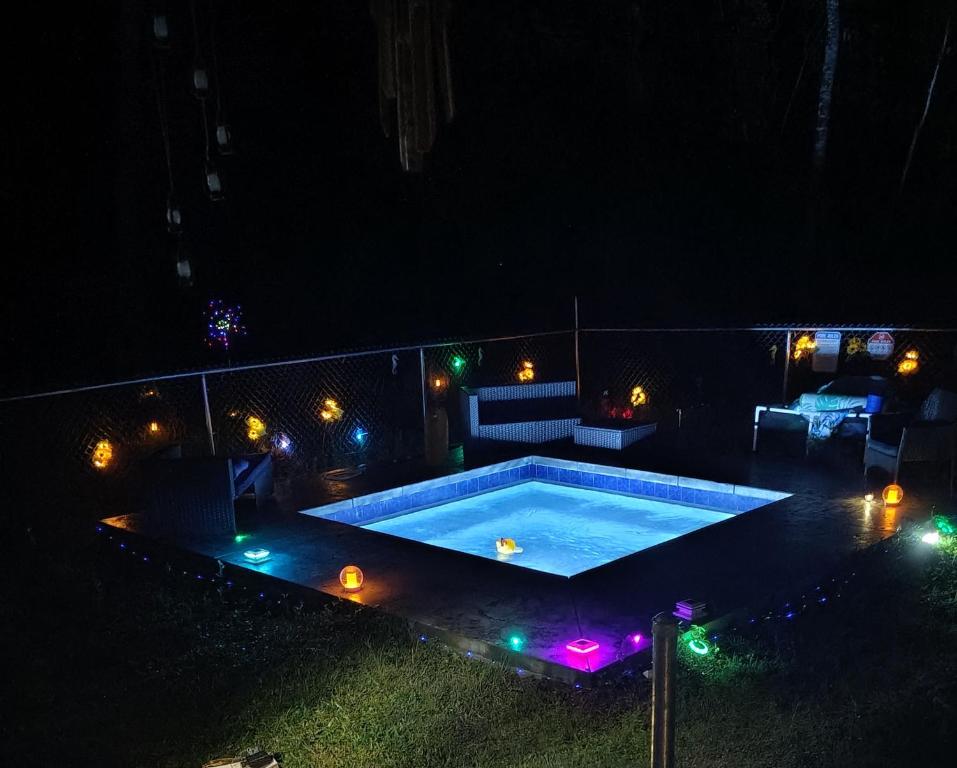 a swimming pool at night with lights around it at Hoomaikai Blessings in Keaau