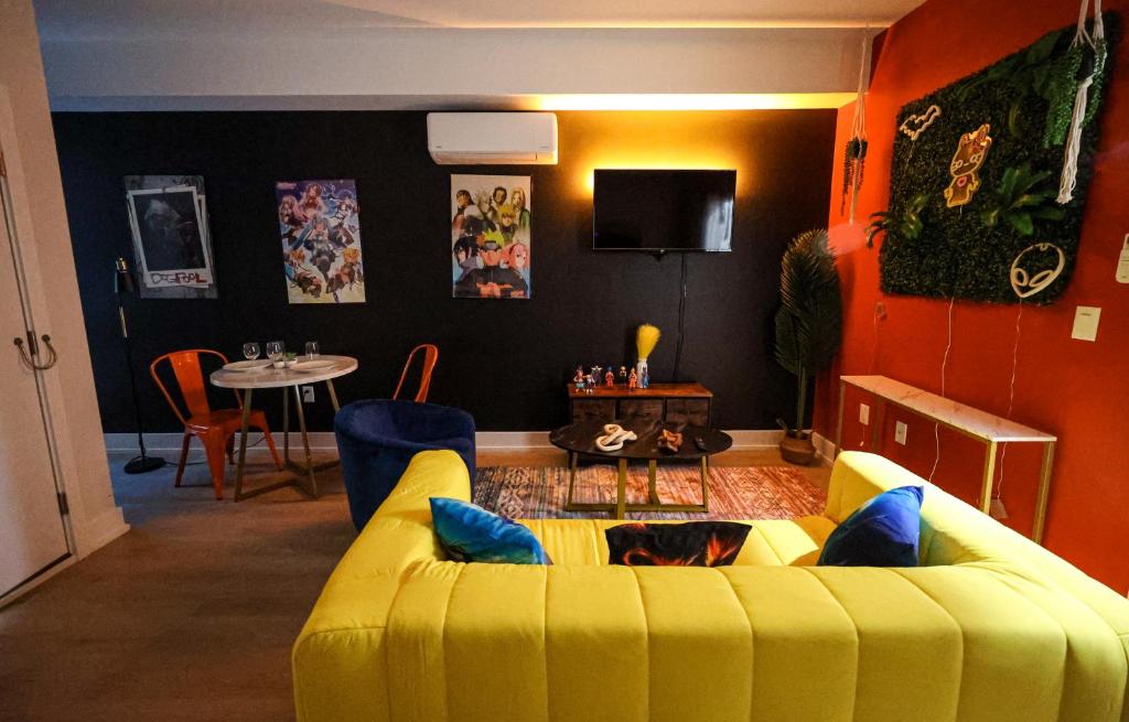 a living room with a yellow couch and a table at Chill in Style Anime Themed Escape in Philadelphia
