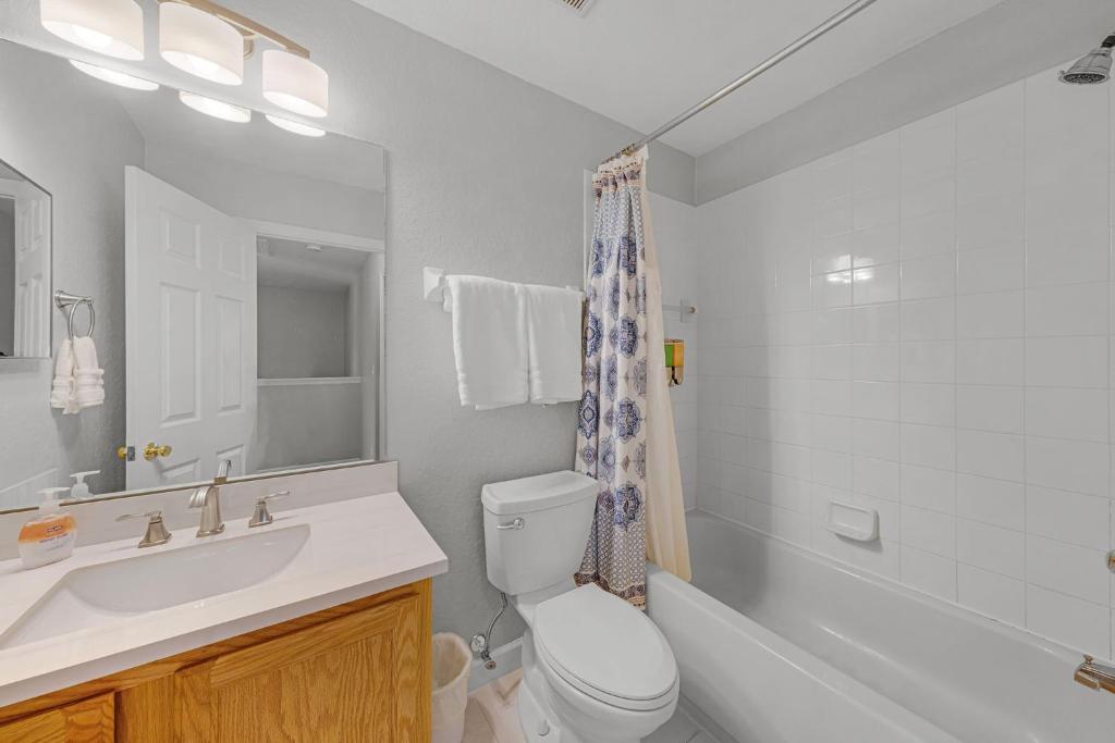 a bathroom with a sink and a toilet and a tub at Camaro in Orlando