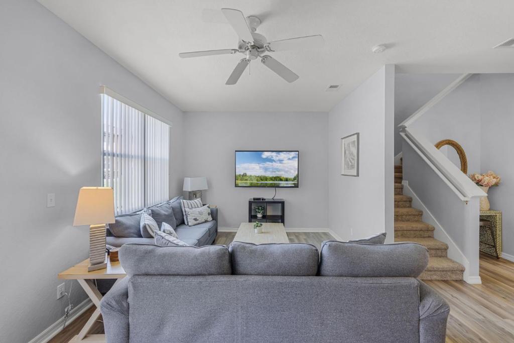 a living room with a couch and a ceiling fan at Camaro in Orlando