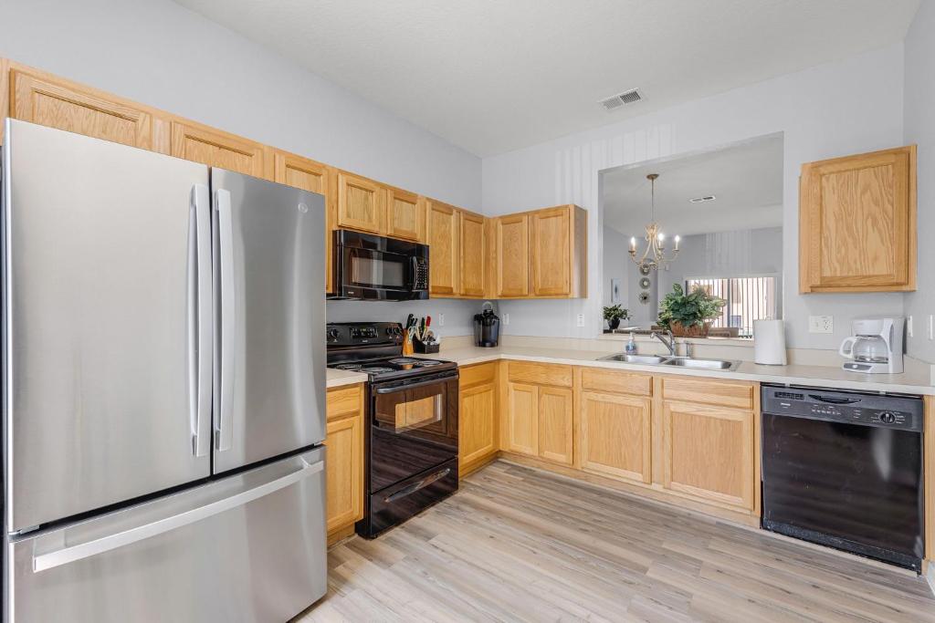 a kitchen with a stainless steel refrigerator and wooden cabinets at Camaro in Orlando