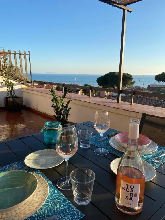 Una mesa con copas de vino y vista al océano. en Belvedere apartment, en Castiglione della Pescaia