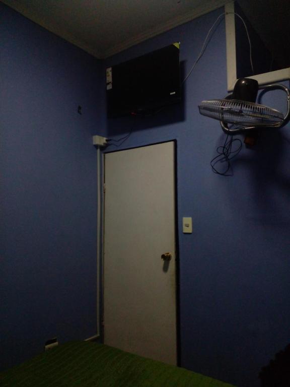 una camera con una parete blu e una porta bianca di Hostal Palmera a Rancagua