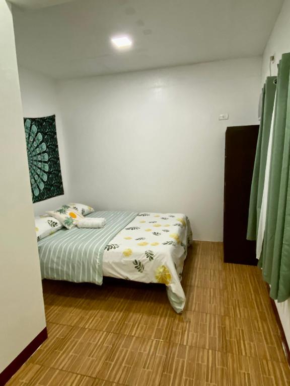 a bedroom with a bed in a room with green curtains at Moalboal Panagsama beach TopBudz Hostel in Moalboal