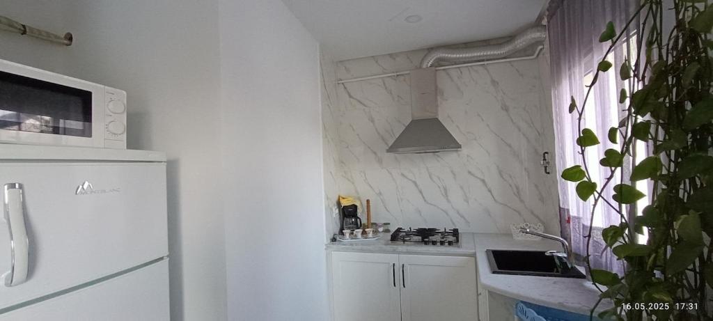 a white kitchen with a sink and a refrigerator at TIM Haute standing appartment S2, center Monastir in Monastir