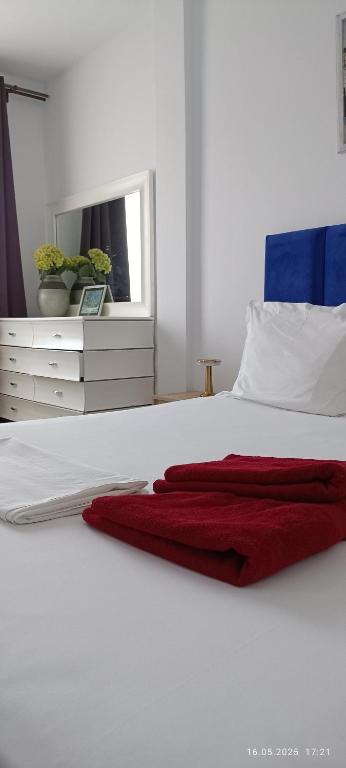 a bedroom with a white bed with a red blanket on it at TIM Haute standing appartment S2, center Monastir in Monastir