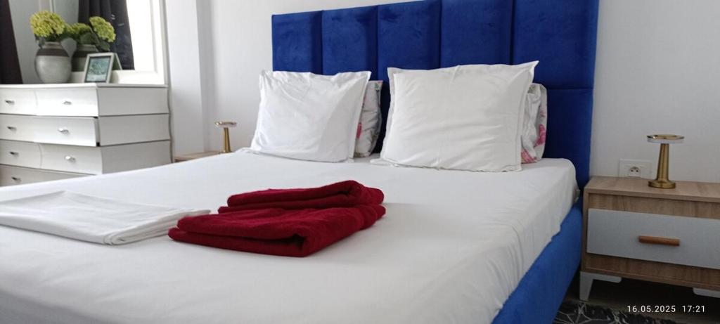 a red blanket laying on a white bed at TIM Haute standing appartment S2, center Monastir in Monastir