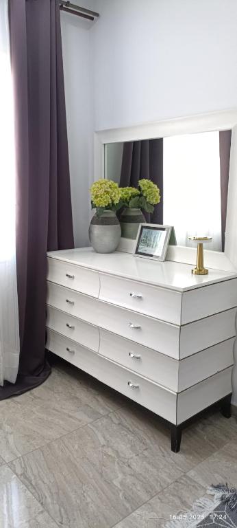 a white dresser with two plants on top of it at TIM Haute standing appartment S2, center Monastir in Monastir