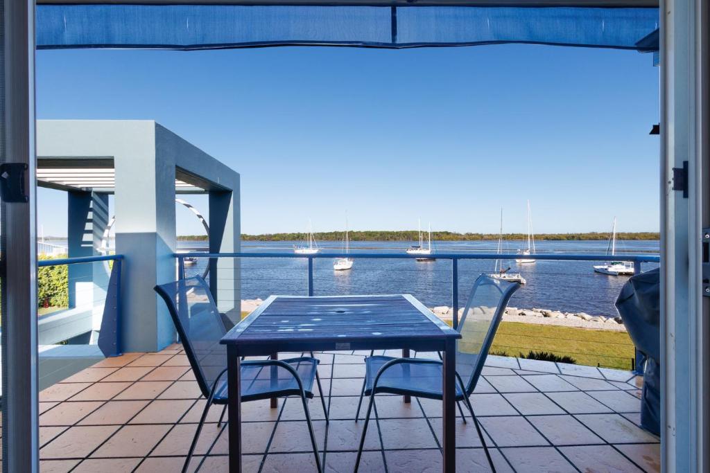 a table and chairs on a balcony with a view of the water at Riverview Apartment 2.6 3-5 Riverview Street in Iluka