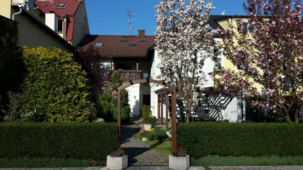 einen Garten mit einem hölzernen Bogen vor einem Haus in der Unterkunft Apartment Pension Stark in Franzensbad