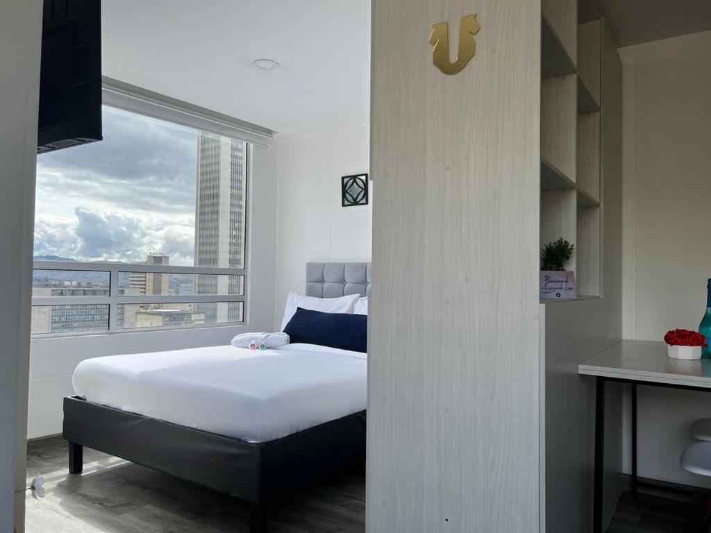 a bedroom with a bed and a large window at Panoramic Luxury of Bogotá in Bogotá