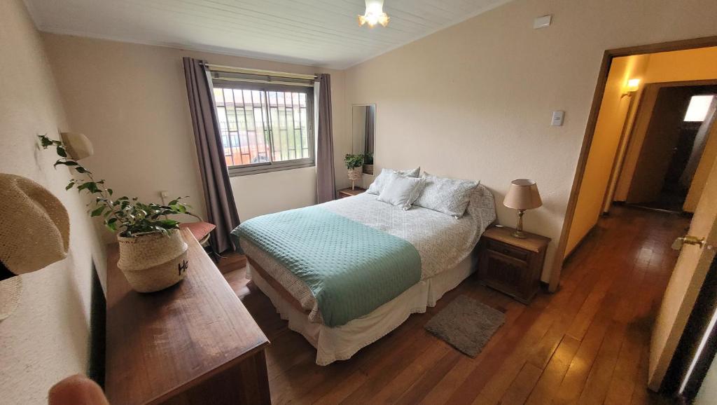 una camera da letto con un letto e una finestra di Amplia casa 7 personas 2 cocheras a Temuco