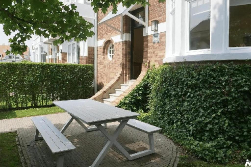 a picnic bench sitting in front of a building at Albatros C0 in De Haan