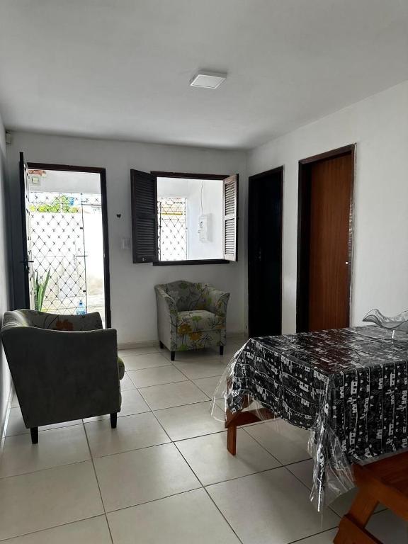 ein Wohnzimmer mit einem Tisch und einem Stuhl in der Unterkunft Casa de Vó in Campina Grande