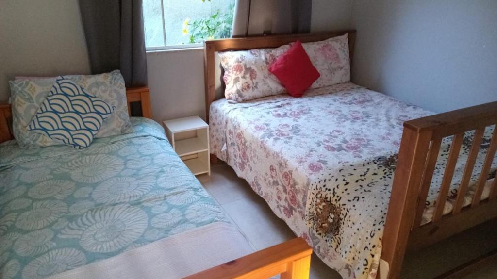 een kleine slaapkamer met twee bedden en een raam bij Casa com piscina in Búzios