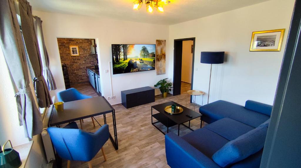 a living room with a blue couch and a table at Golden Hop Apartments in Senftenberg