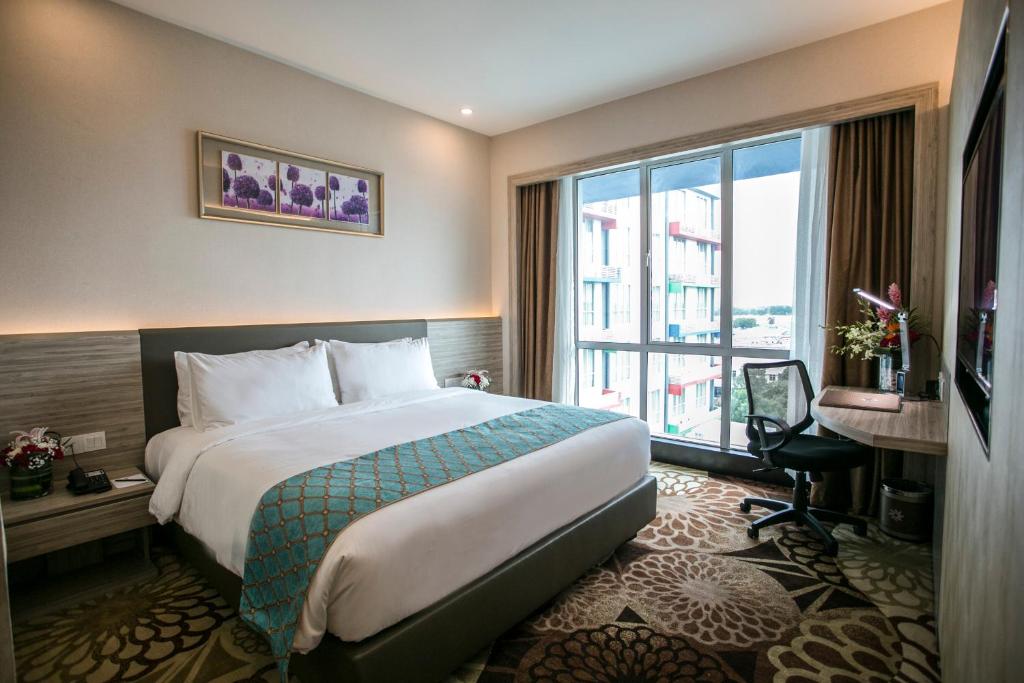 a hotel room with a bed and a large window at V8 Hotel Johor Bahru in Johor Bahru