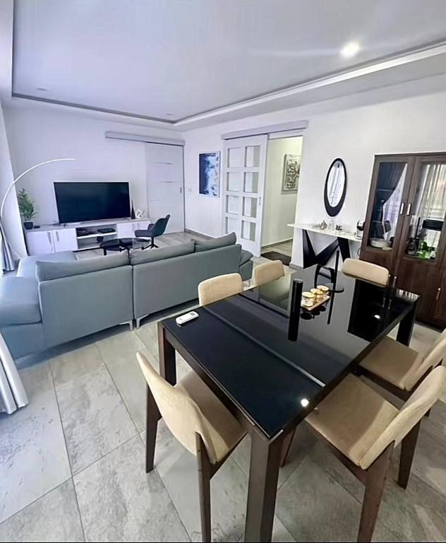 ein Wohnzimmer mit Sofa, Tisch und Stühlen in der Unterkunft OBDP House in Abidjan