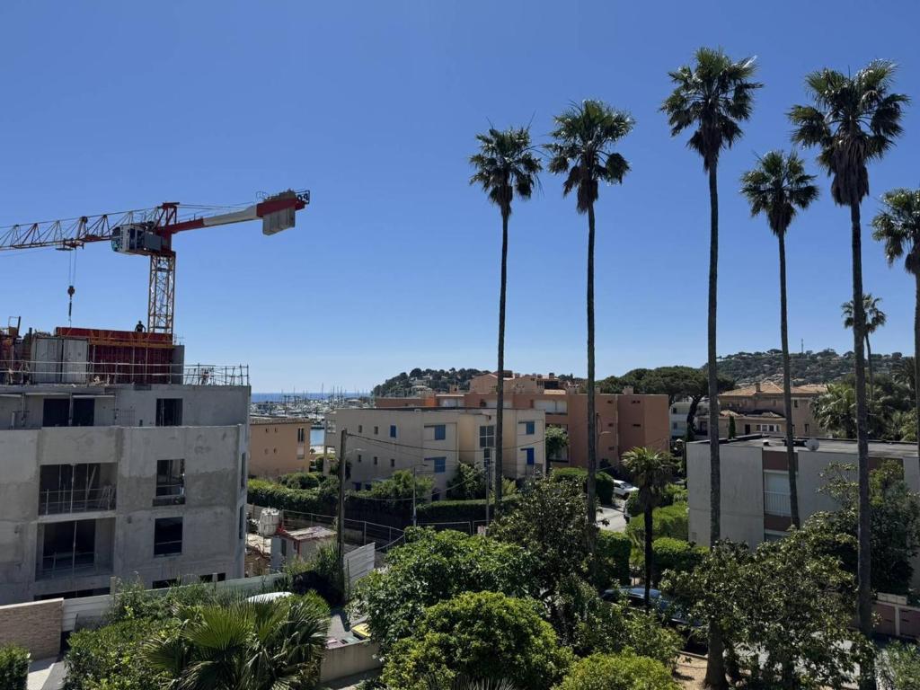 un groupe de palmiers et une grue dans l'établissement Charmant appartement avec parking et A/C proche plage - FR-1-100-357, à Cavalaire-sur-Mer