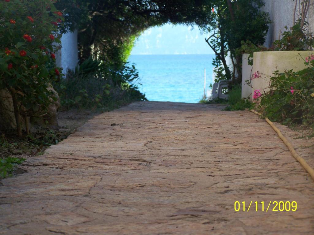 a stone path leading to the ocean with an archway at Bona Ciurrata in Golfo Aranci