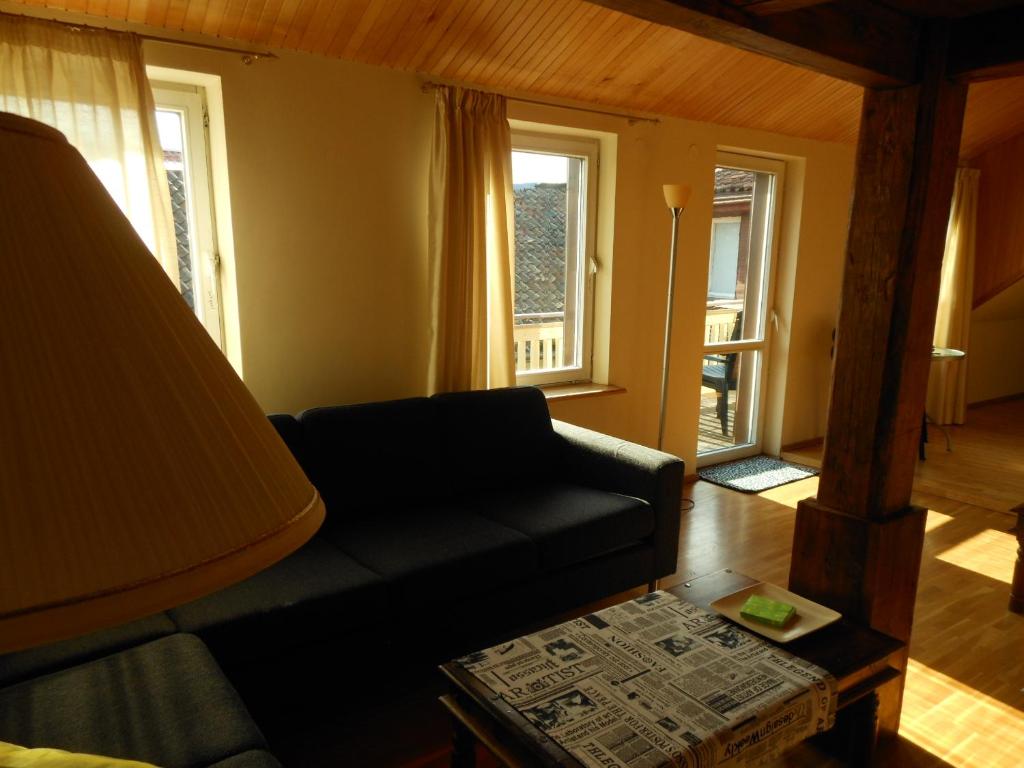 a living room with a couch and two windows at Daukanto Apartments in Vilnius