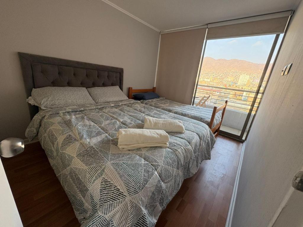 a bedroom with a bed with a large window at Hermoso Departamento central en Antofagasta EDIFICIO ICONO in Antofagasta