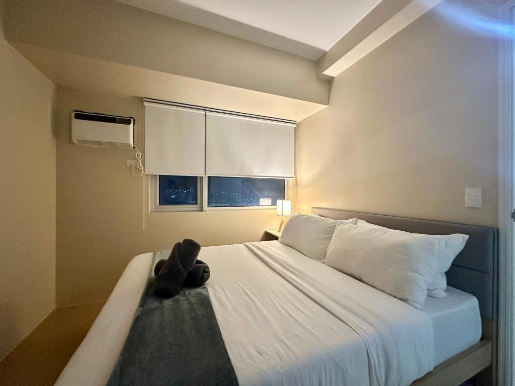 a teddy bear sitting on a bed in a bedroom at Pool View Cozy 1-Bedroom Unit Avida Aspira Tower 2 in Cagayan de Oro