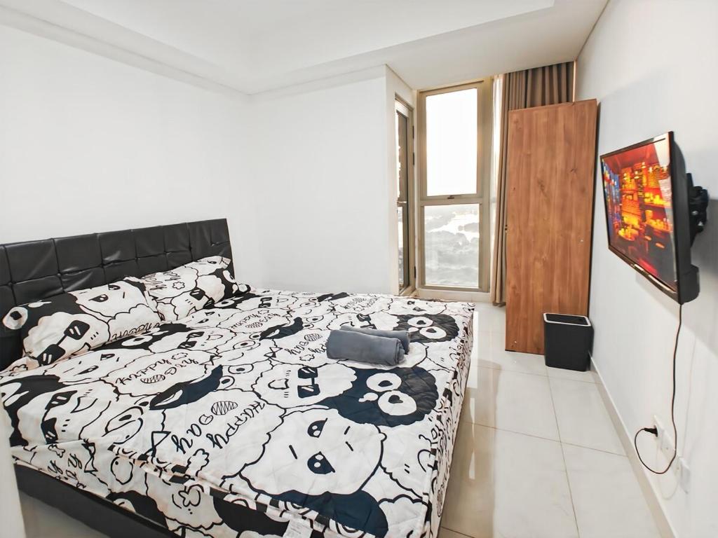 Ένα ή περισσότερα κρεβάτια σε δωμάτιο στο Cozy Gold Coast 1BR PIK Apt with Pool & Gym by 2ndHome