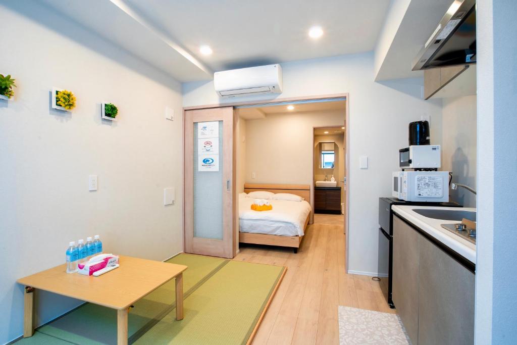 a small room with a bed and a kitchen at Uhome Fabric Hotel in Tokyo