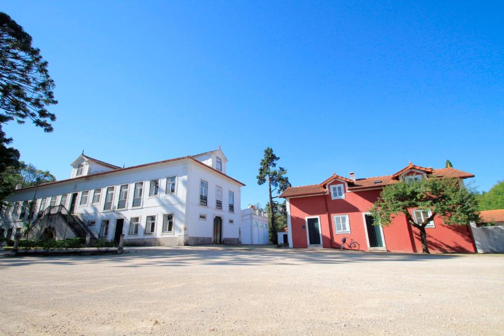 un gran edificio blanco junto a un edificio rojo en Casa de Mogofores, en Anadia