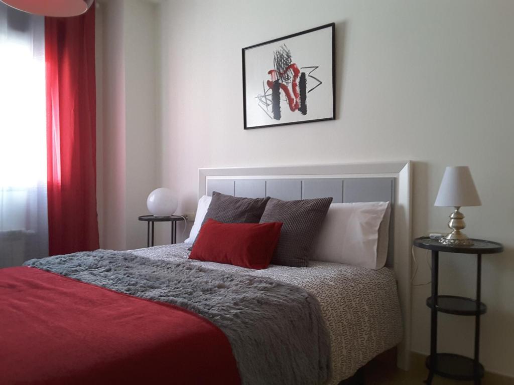 a bedroom with a bed with a red blanket at Apartamento Berenguela in Córdoba
