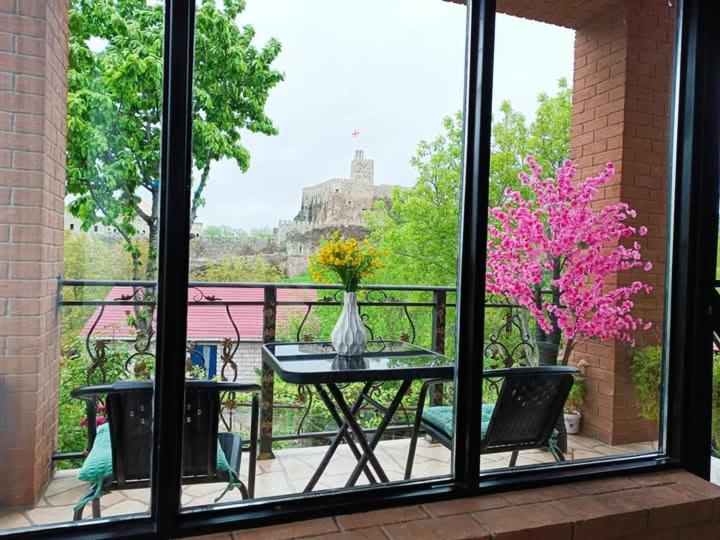 a balcony with a table and a vase of flowers at Panorama RABATI in Akhaltsikhe
