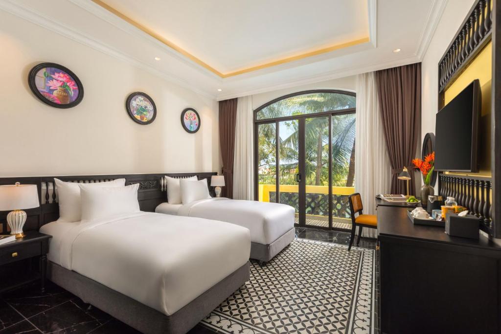 Giường trong phòng chung tại Nesta Hoian Resort & Spa