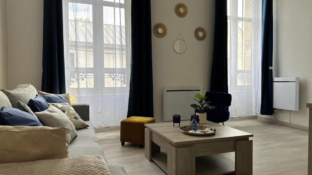 un salon avec un canapé et une table basse dans l'établissement Bel appartement proche gare, à Nevers