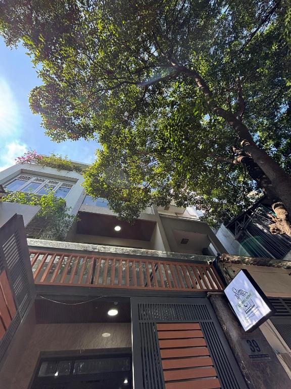 a house with a wooden gate and a tree at SQUIRRELHOME District8 in Ho Chi Minh City
