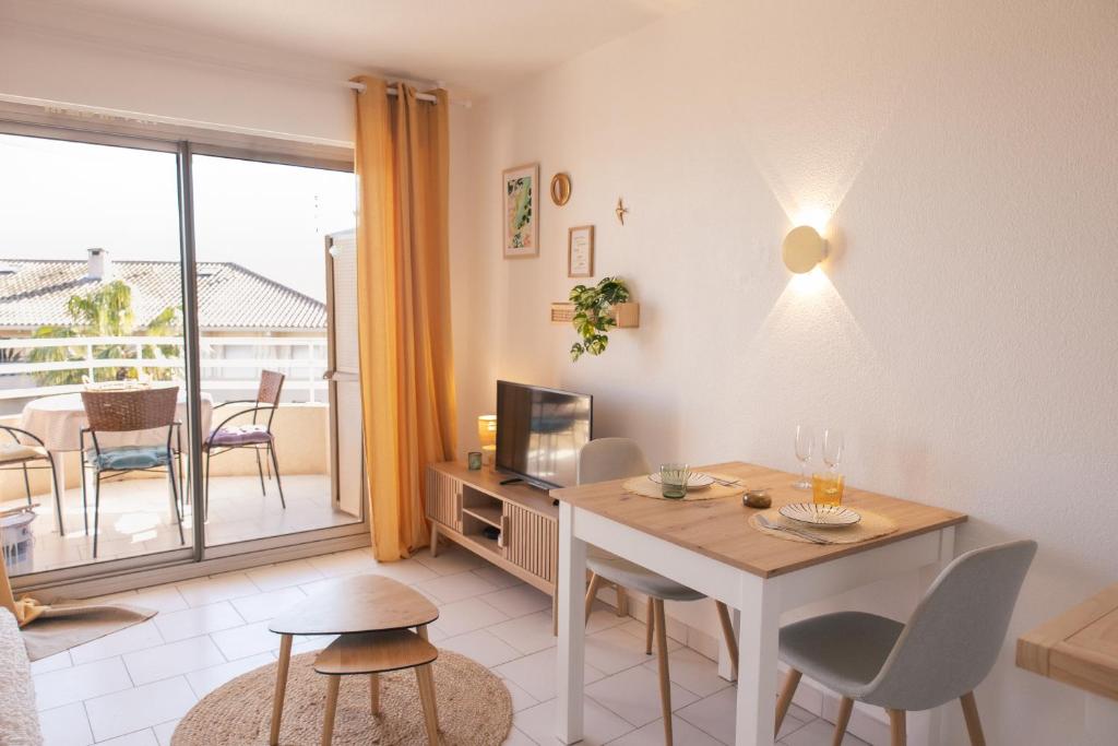 un salon avec une table à manger et une télévision dans l'établissement Sous le Soleil, à Fréjus
