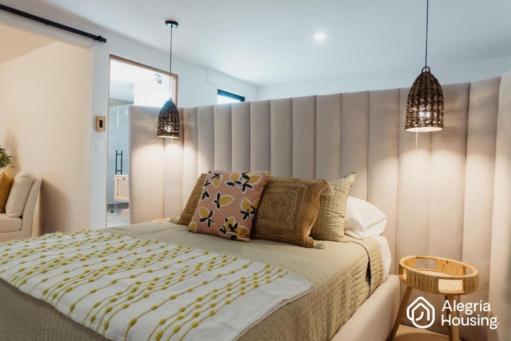 a bedroom with a bed with a large headboard at 202 Arje Suites Campestre by Alegría Housing in Las Pilas