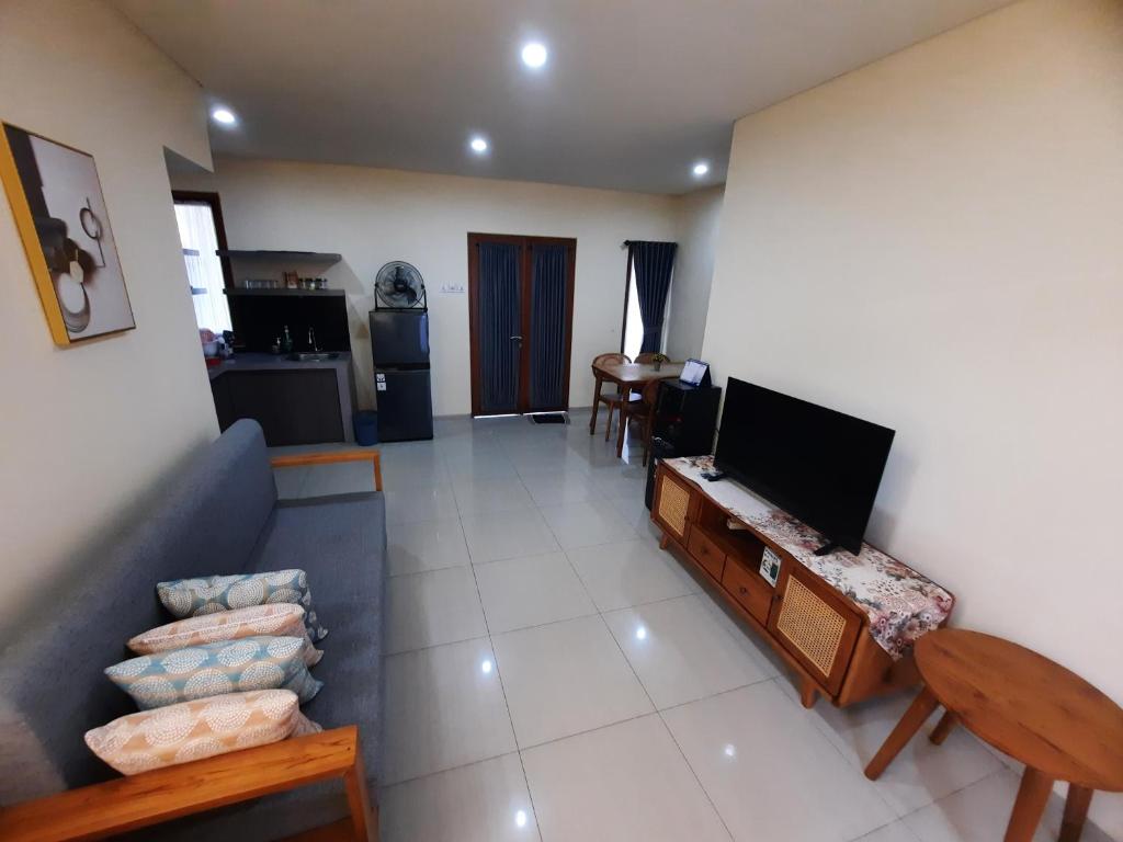 een woonkamer met een flatscreen-tv en een bank bij Bali Oma Living in Denpasar