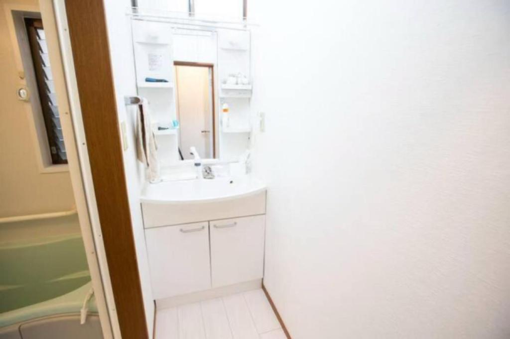a bathroom with a white sink and a mirror at 新宿久久小木屋 整栋出租 in Tokyo