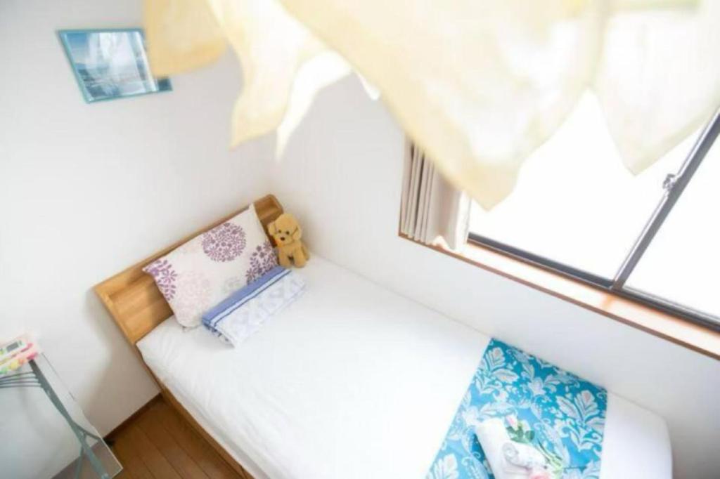 a small bed in a room with a window at 新宿久久小木屋 整栋出租 in Tokyo