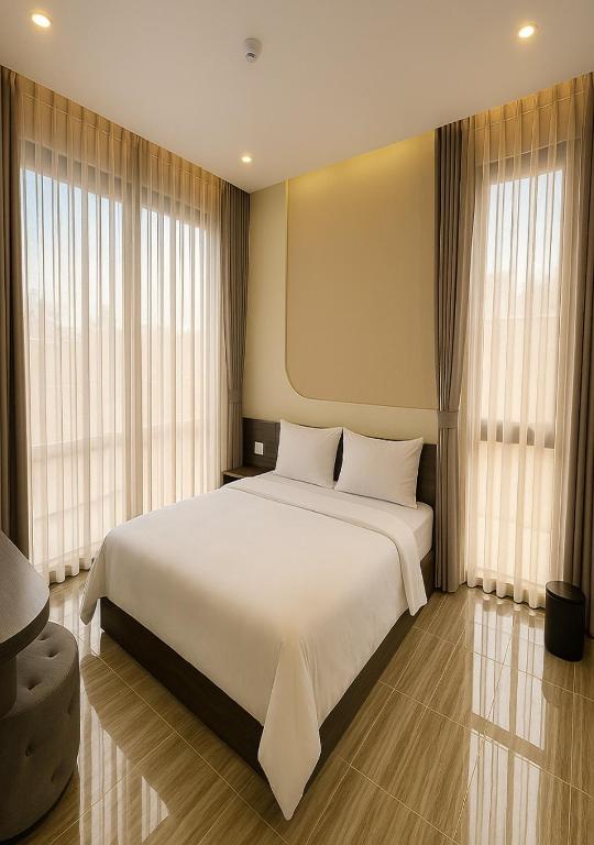 a large white bed in a room with windows at Tuyet Suong Hotel in Quang Ngai